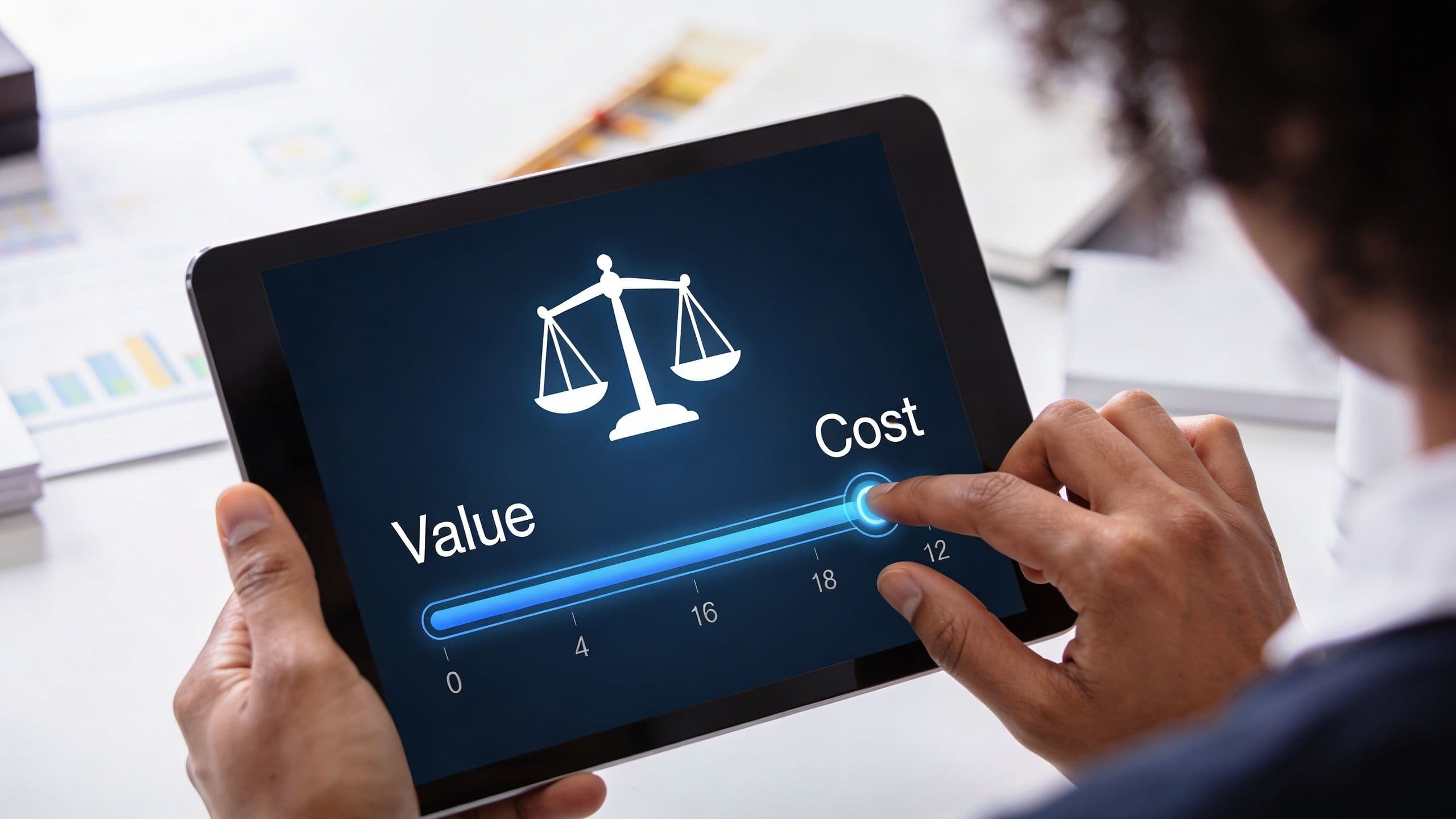 A person using a tablet to adjust a slider bar measuring the balance between value and cost.