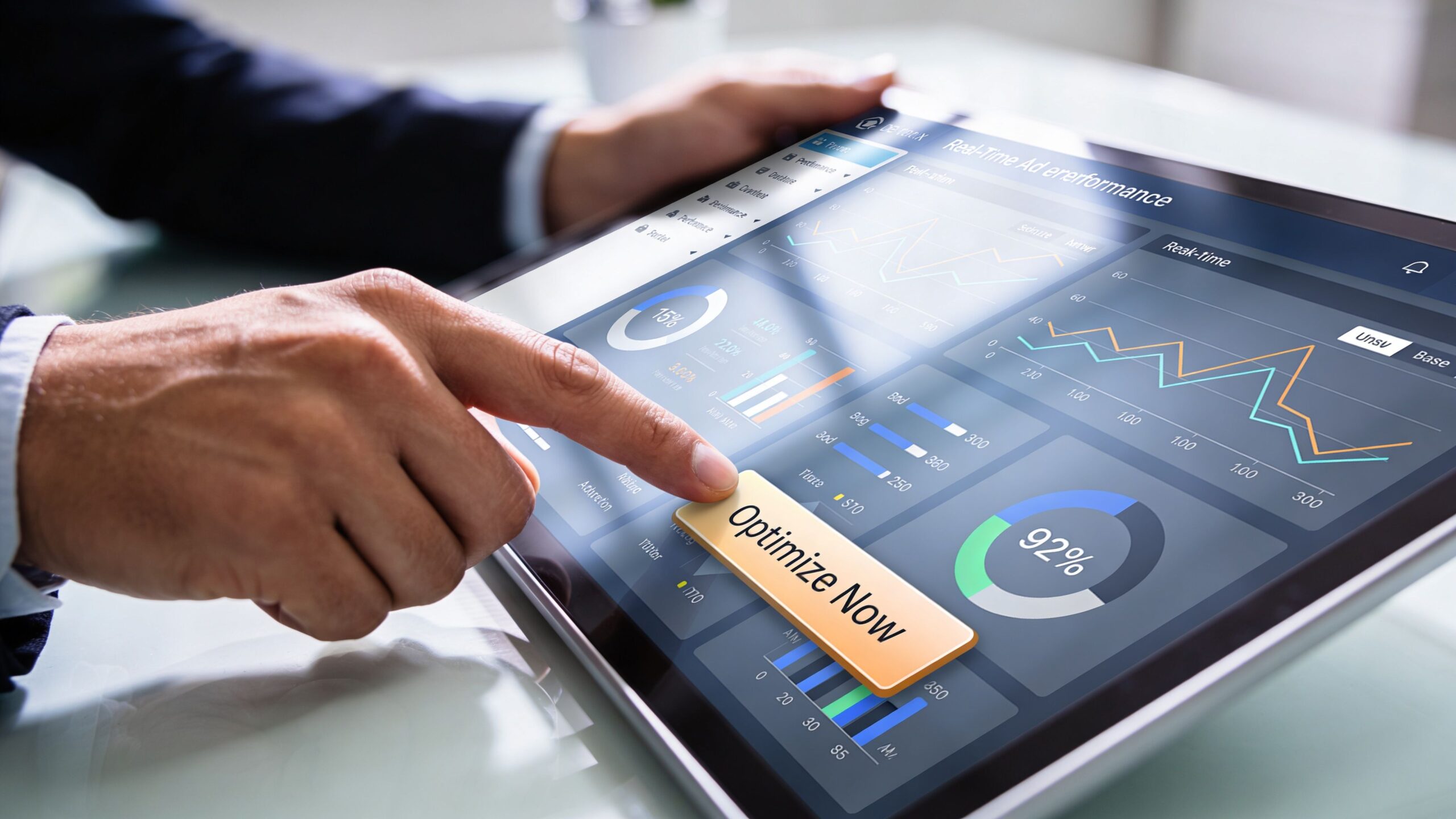 A business professional using a digital tablet to analyze real-time advertisement performance metrics on a dashboard.
